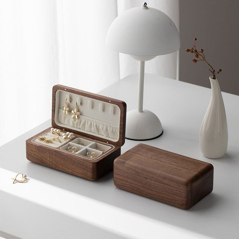 The image showcases two wooden jewelry boxes placed on a white table.