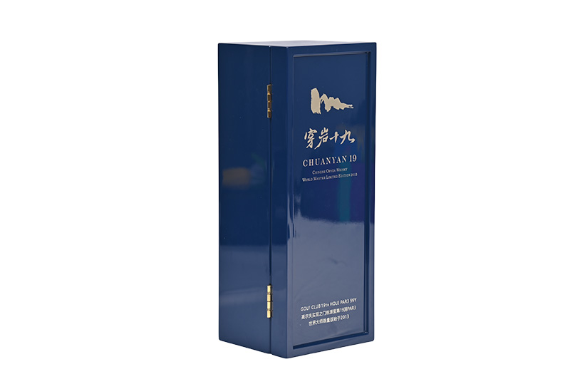 Ângulo de vista da caixa de presente de vinho de madeira azul fechado com perfil lateral visível e pequena trava de metal dourado. Embalagem de garrafa única premium da Brothersbox.
