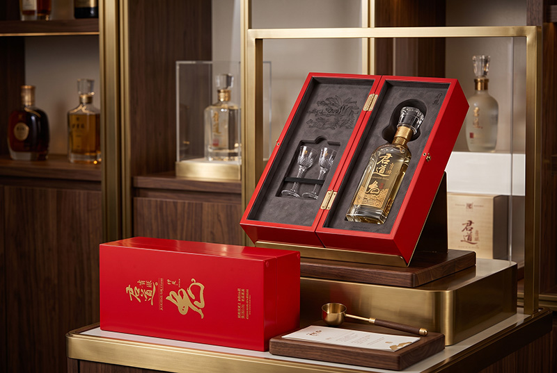 Boîte de rangement de vin en bois rouge de luxe affichant une bouteille de liqueur premium et des verres de dégustation