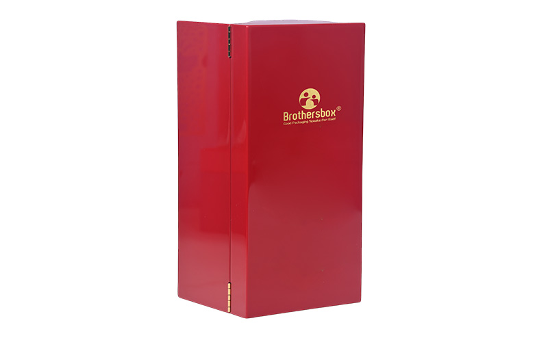 Left angle view of red piano finish wooden wine gift box highlighting gold metal hinges