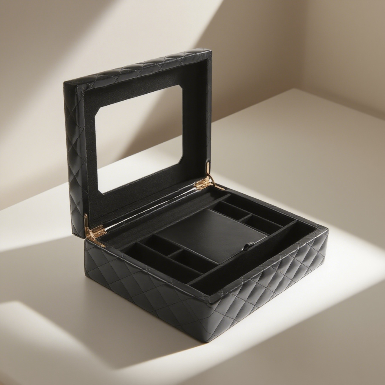 The image showcases an open, black quilted jewelry box placed on a light - colored surface. The box lid, adorned with a diamond - shaped stitching pattern, has an integrated rectangular mirror on the 