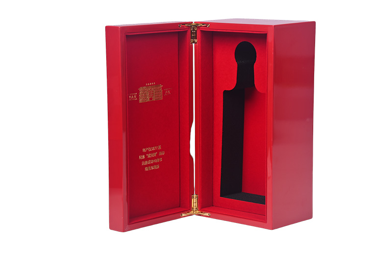 Open red wooden wine box revealing red velvet interior and gold foil stamping