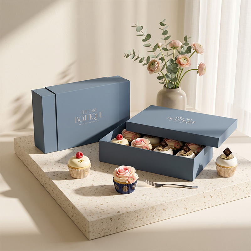 High-end paper cake gift boxes displaying gourmet decorated cupcakes in a bright lifestyle setting