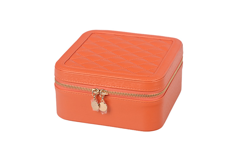 Vista en perspectiva de un organizador de joyas cuadrado naranja personalizado con costuras de diamantes elegantes.