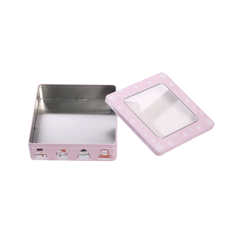 open pink square Christmas tin cookie box with lid resting to the side