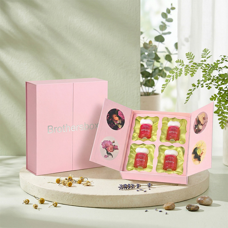 Caixa de presente elegante da fragrância cor-de-rosa exibida em um pedestal de pedra com flores secas.