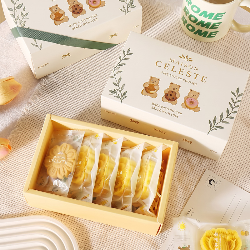 Complete and open drawer-style cookie gift boxes with green ribbons.