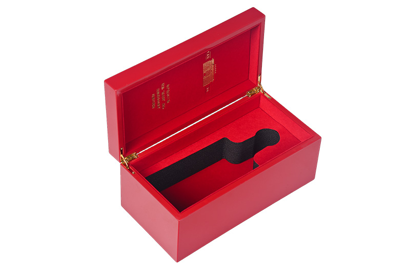High-gloss red wooden wine presentation box lying open with custom internal compartments