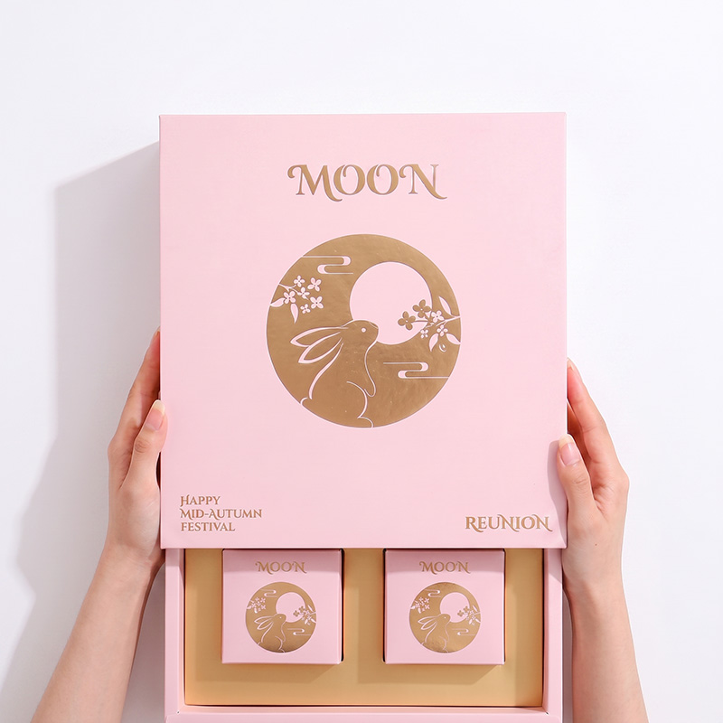 Hände öffnen eine rosa Schiebe-Mooncake-Geschenk box mit einem luxuriösen Gold-Innen tablett
