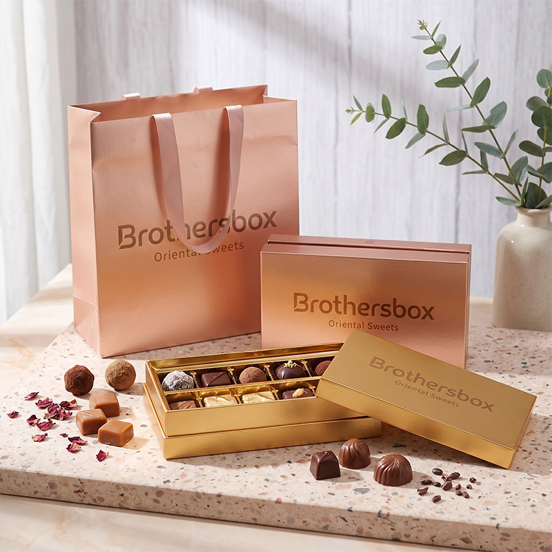 Conjunto de caja de regalo de chocolate surtido de lujo lleno de trufas y pralines sobre fondo de terrazo