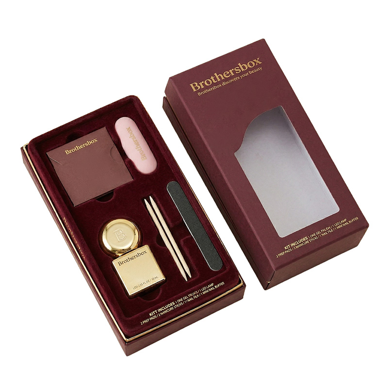 Ouvrez la boîte personnalisée de kit de soin d'ongle révélant le plateau d'insertion de velours de bourgogne et les accessoires de manucure.