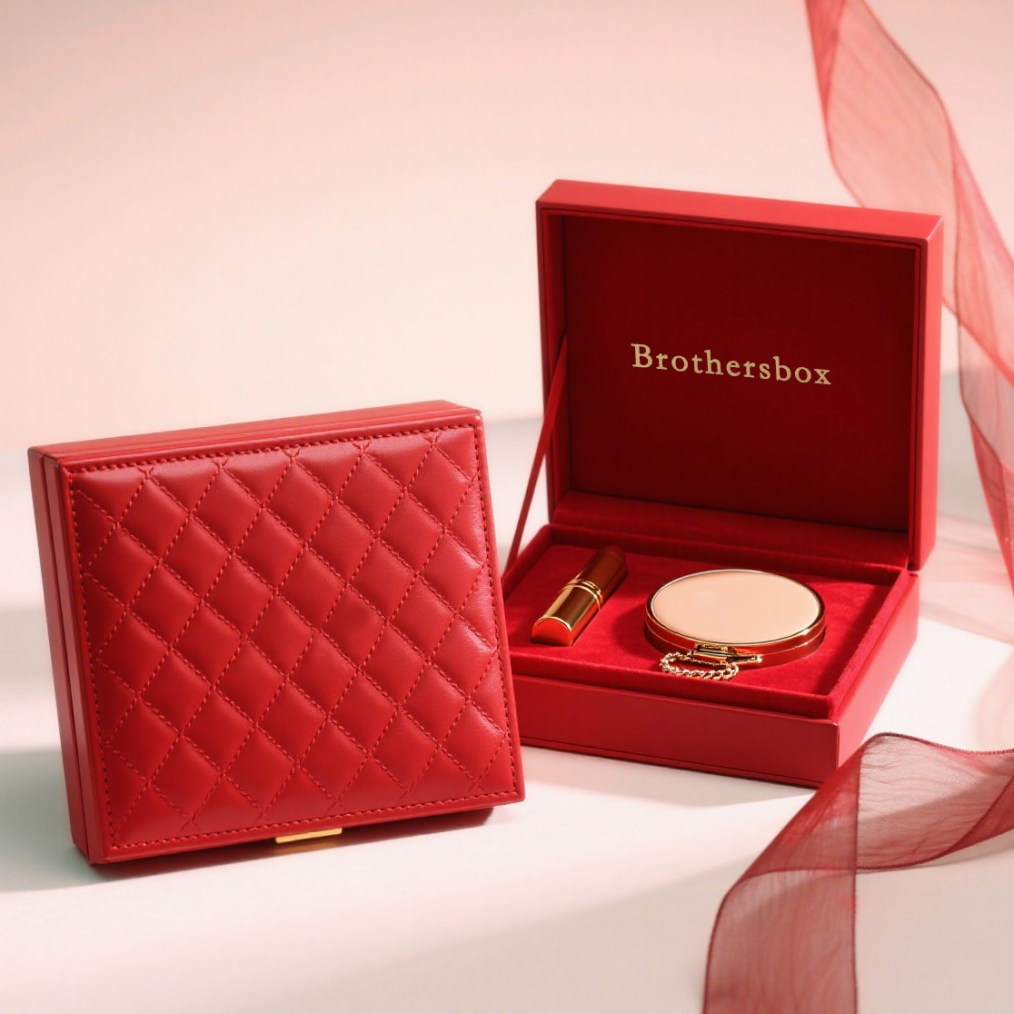 The image showcases two red leather boxes against a soft, light pink backdrop. One box is closed, featuring a diamond - quilted pattern and a gold latch.