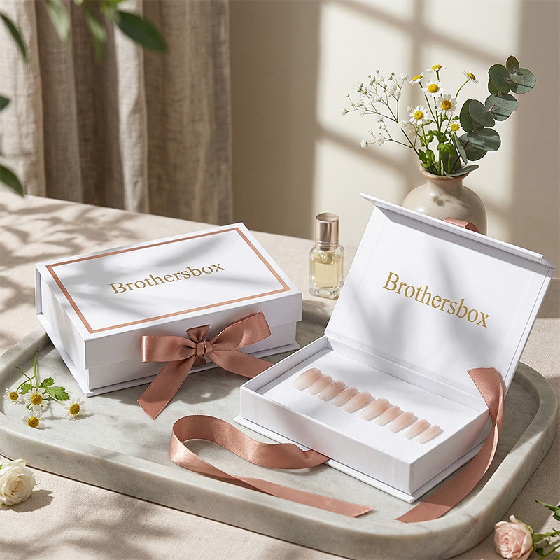 Boîtes d’emballage personnalisées pour ongles press-on, de style livre, de Brothersbox, présentées avec élégance sur un plateau en marbre.