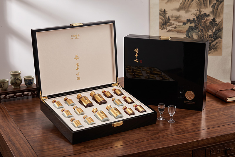 Caixa de degustação de licor de madeira de luxo exibindo mini garrafas de amostra e copos de degustação na mesa de madeira