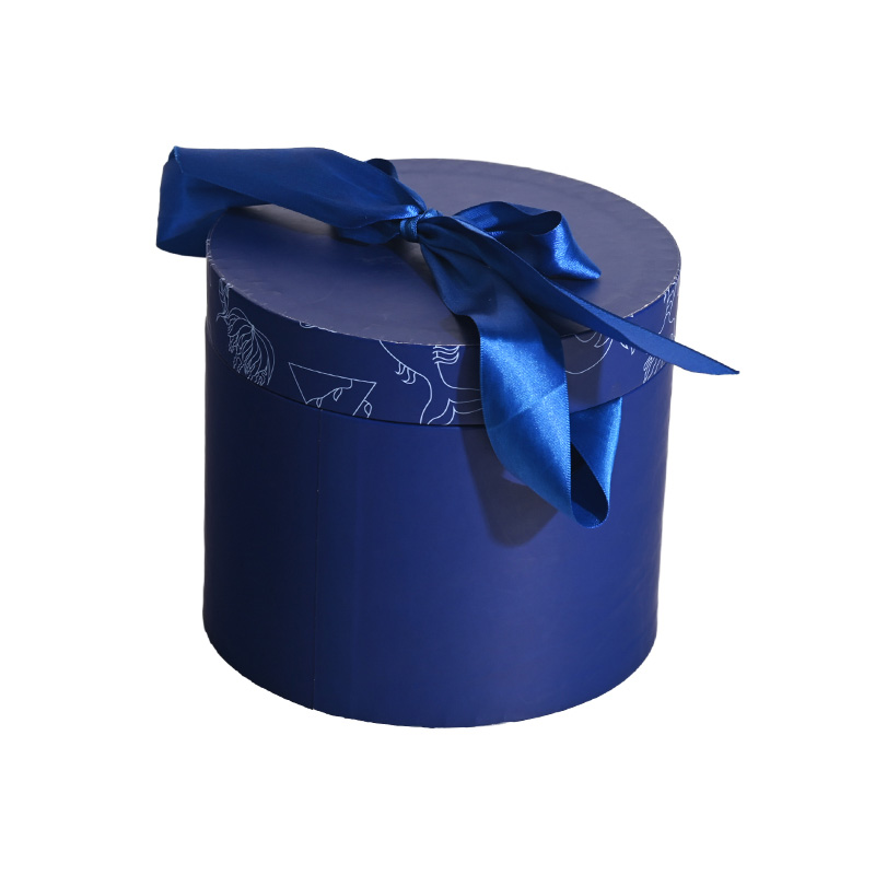 High-angle view of a premium blue cylindrical cake box showcasing a hand-tied satin ribbon bow.