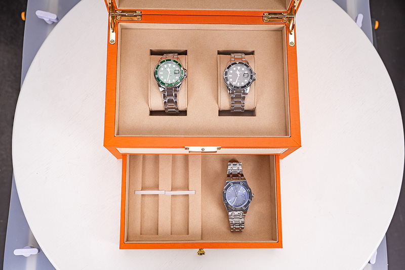 Vista de arriba hacia abajo de la caja de almacenamiento de relojes para hombre de lujo con compartimento superior y cajón inferior abierto