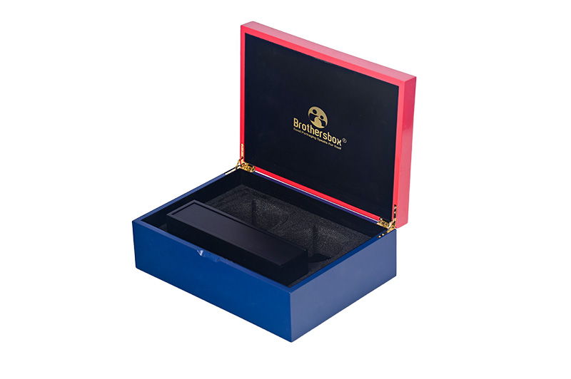 Vue inclinée d'un thé en bois deux tons ouvert boîte cadeau révélant compartiments en mousse de protection et de l'or charnières.