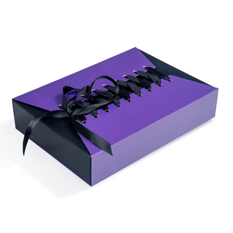Detailed top view of a striking purple and black corset gift box featuring metal eyelets and a satin bow.
