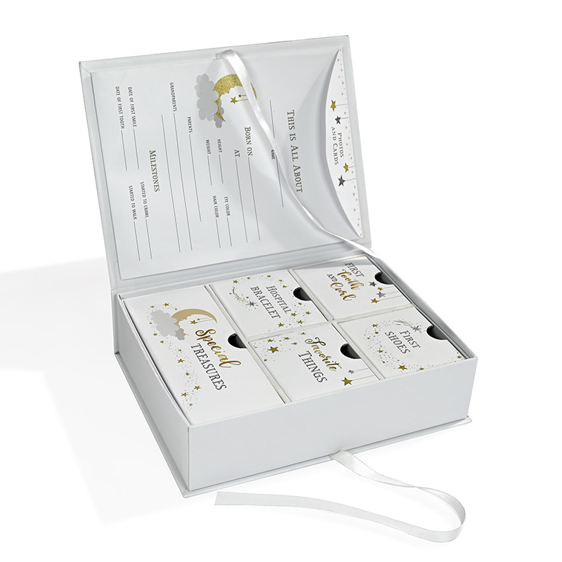 High-quality paper packaging baby milestone box highlighting gold foil text on internal drawers.