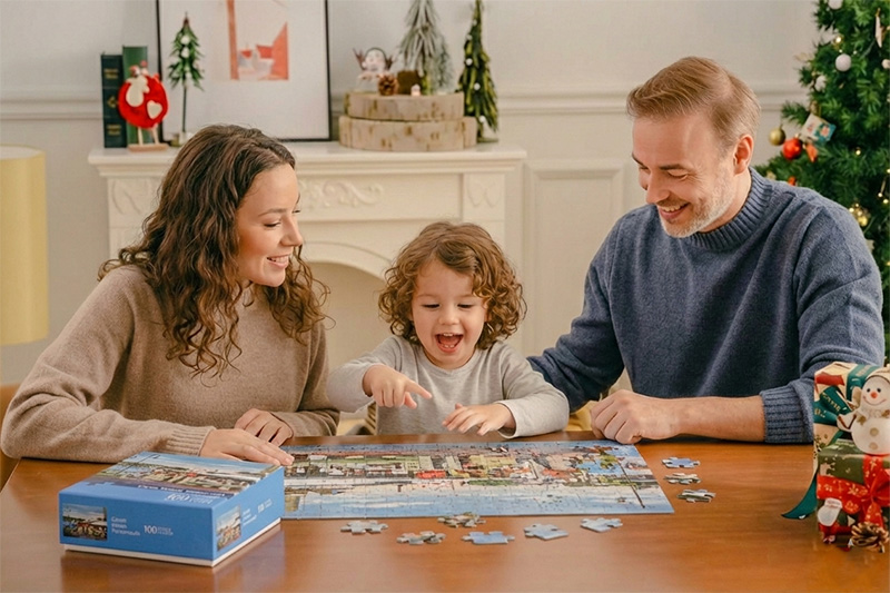 青い箱にカラフルな100ピースのジグソーパズルでホリデーシーズンの家族の楽しみ。